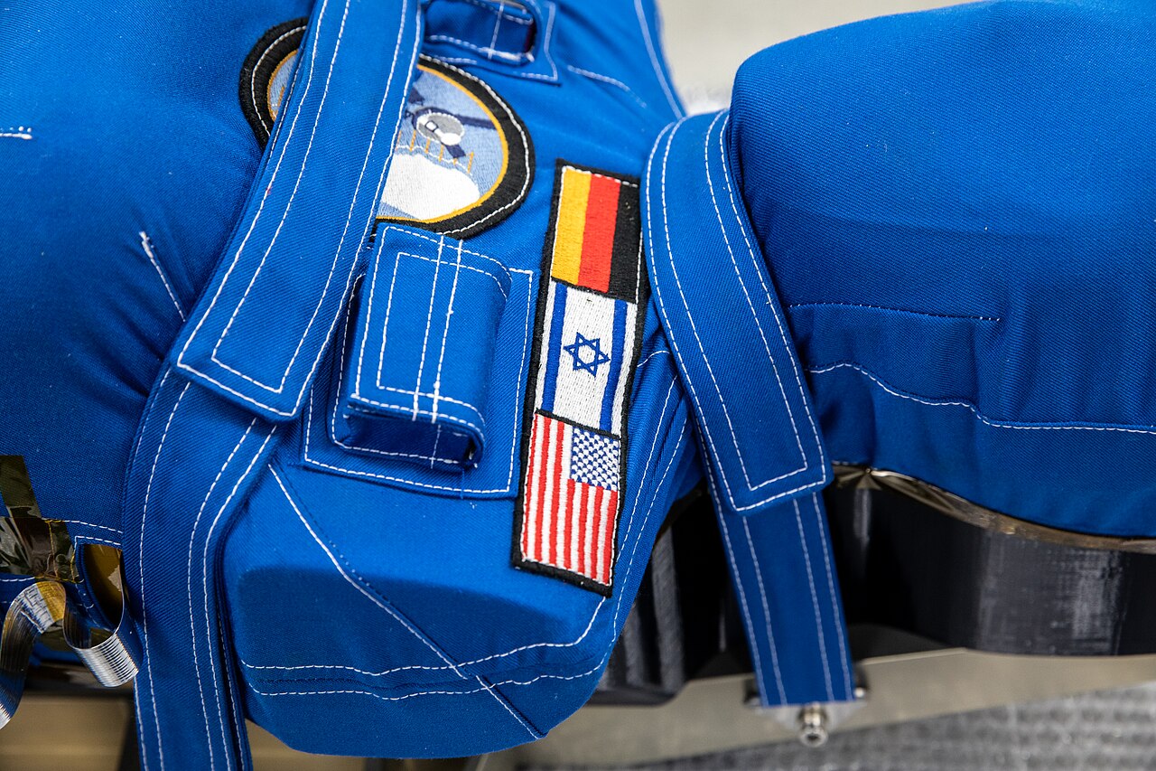 A radiation phantom in a blue protective vest carrying German and Israeli flags